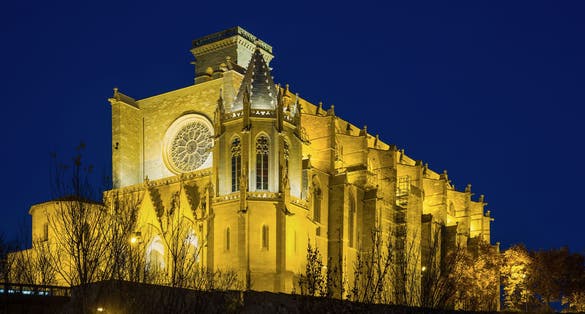Photo of Basilica of Santa Maria de la Seu with evening lights in Manresa, Spain.