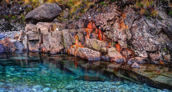 Photo of Rusted rocks in Fairy Pools, Glen Brittle, Isle of Skye, Inner Hebrides, Highlands, Scotland .