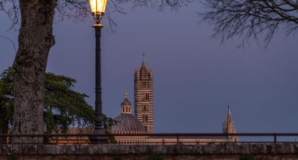 photo of Siena Cathedral from Fortezza Medicea after sunset with illuminated lamp, Siena, Tuscany, Italy