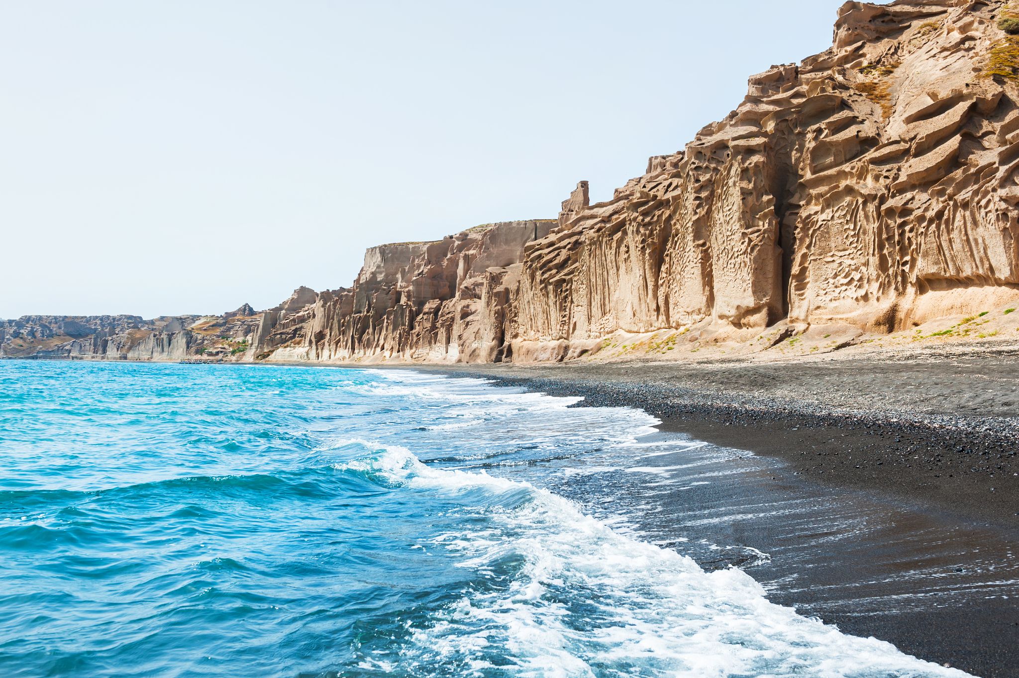 Photo of beautiful beach with volcanic mountains and black sand. Vlychada beach, Santorini island, Greece.