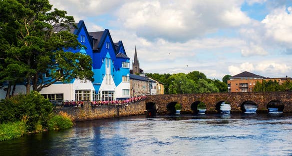 photo of view of Sligo, Ireland. Beautiful landscape in Sligo, Ireland with river and colorful houses. Cloudy sky in summer, old bridge over the river