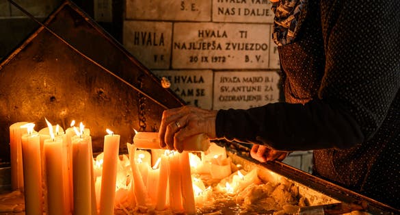 Photo of Lighting candles in Kamenita vrata (Stone Gate) to remember and honor the deceased loved ones.