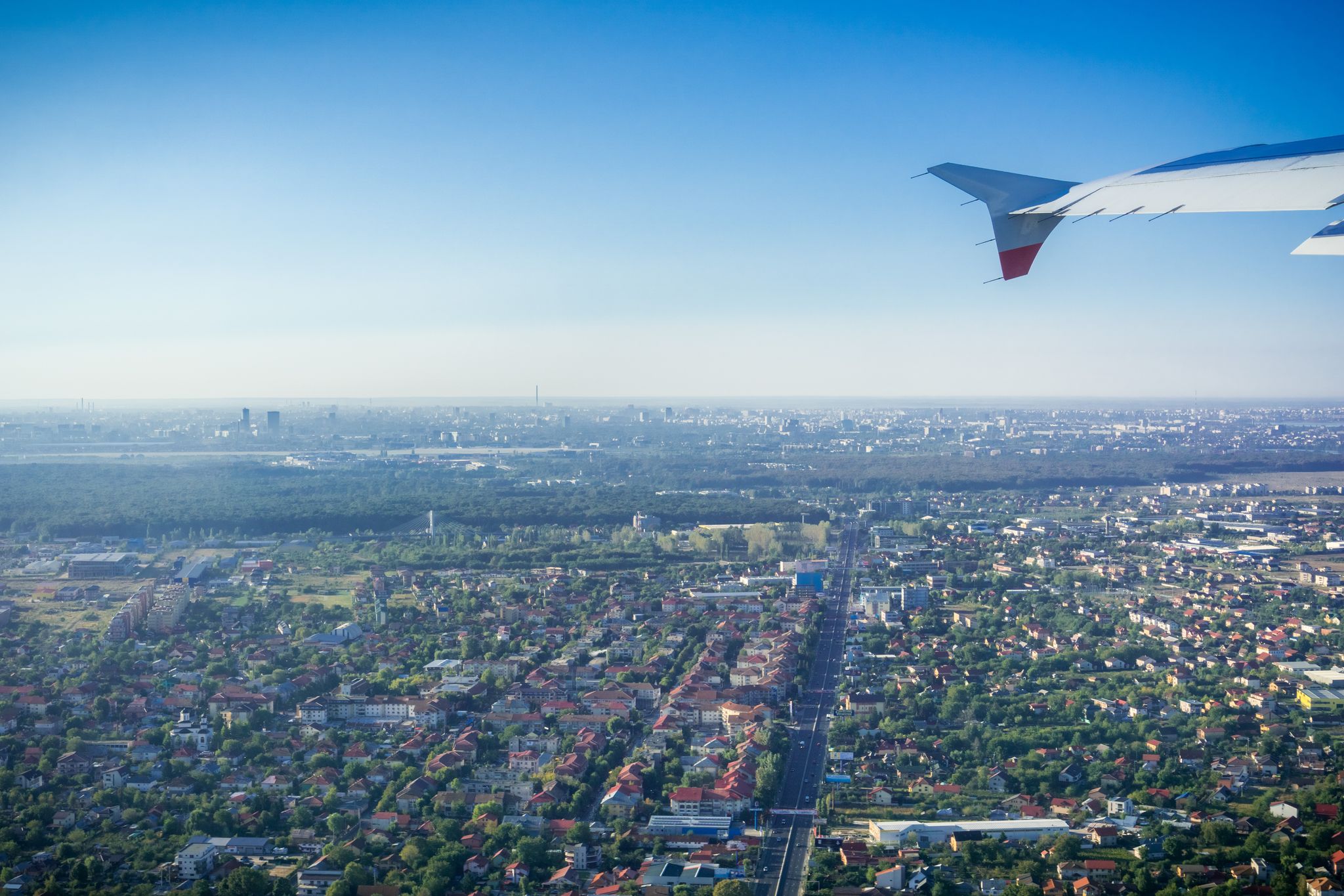 photo off view of Taking off from Otopeni airport; flying over residential neighborhoods, Bucharest skyline in the background; Romania