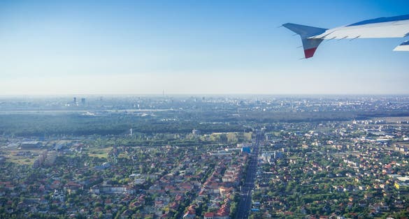 photo off view of Taking off from Otopeni airport; flying over residential neighborhoods, Bucharest skyline in the background; Romania