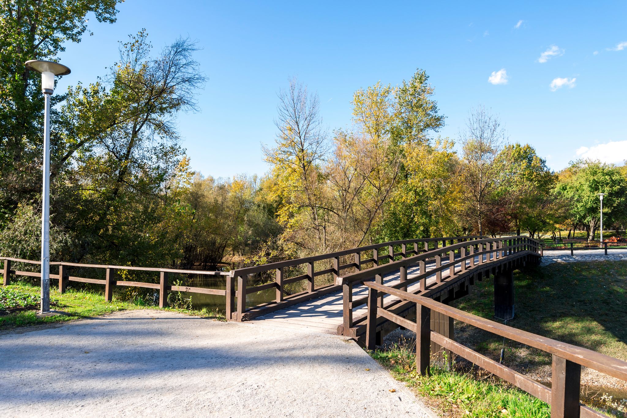 Photo of light post and a wooden bridge in Bundek city park, Zagreb, Croatia.