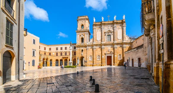 Morning as tourists begin to explore the Brindisi Duomo Cathedral and Bell tower in the Piazza Duomo in Brindisi, Italy, part of the southern Puglia region.
