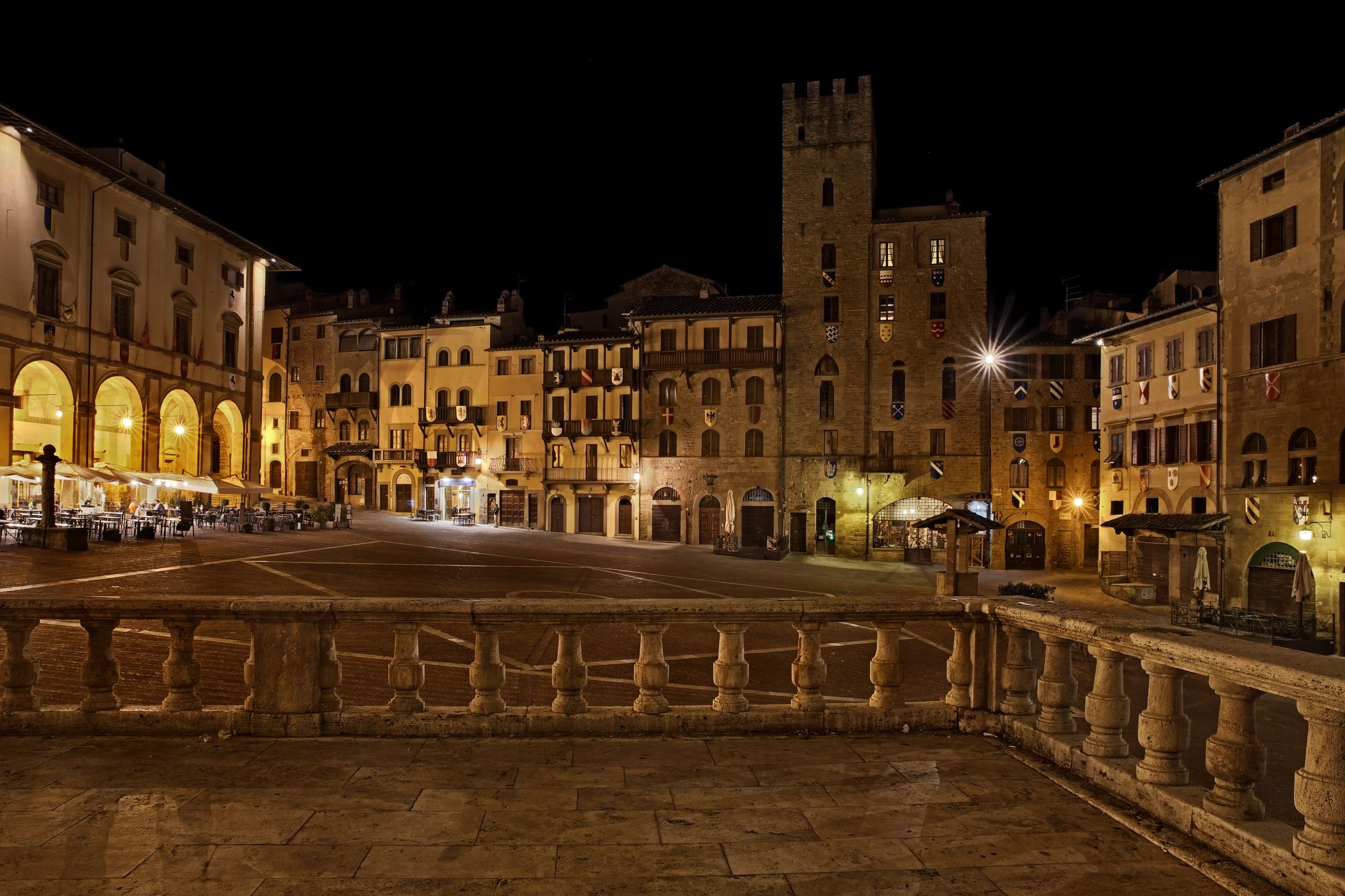 PHOTO OF Arezzo, Tuscany, Italy: night view of the main square Piazza Grande, with the medieval buildings, in the old town of the ancient Italian city of art .