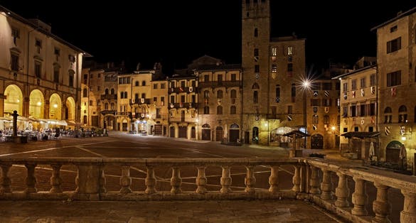 PHOTO OF Arezzo, Tuscany, Italy: night view of the main square Piazza Grande, with the medieval buildings, in the old town of the ancient Italian city of art .
