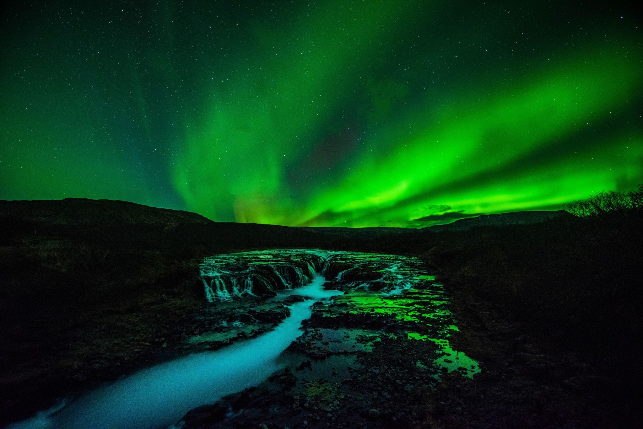 photo of Iceland Brúarfoss waterfall night view with northern light.
