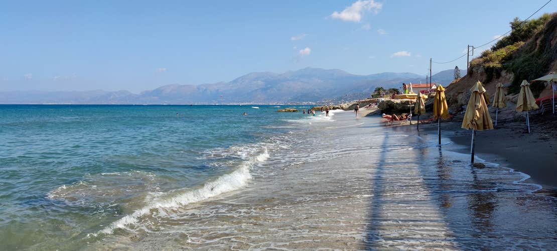 Photo of beautiful view of a beach with a lapping wave and mountains in the background, Anissaras ,Greece.