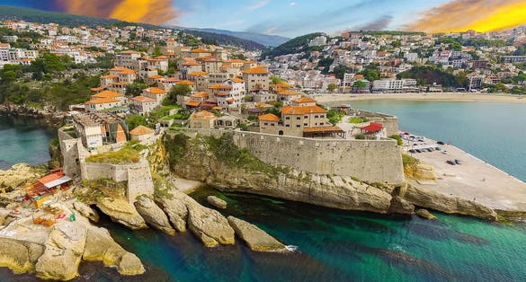 Photo of beautiful sunset over ulcinj is town on coast of Montenegro, aerial view on Ada Bojana Island and old Ulcinj Castle.