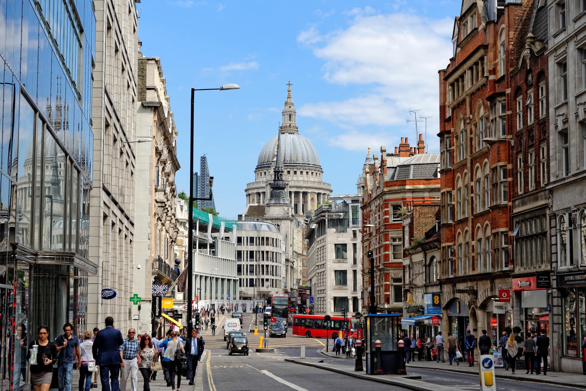 View of St. Paul’s Cathedral from a busy London street with red buses and pedestrians on a sunny July day..jpg