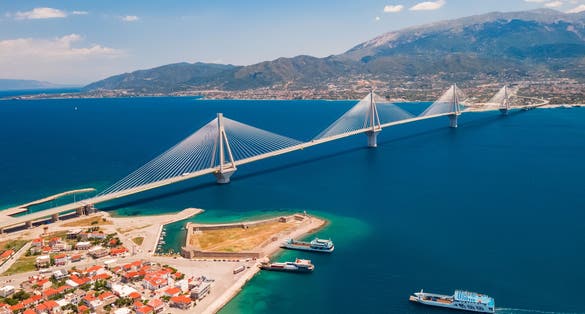 Photo of aerial view from a drone on a beautiful large bridge for a highway across the sea in Patras, Greece.