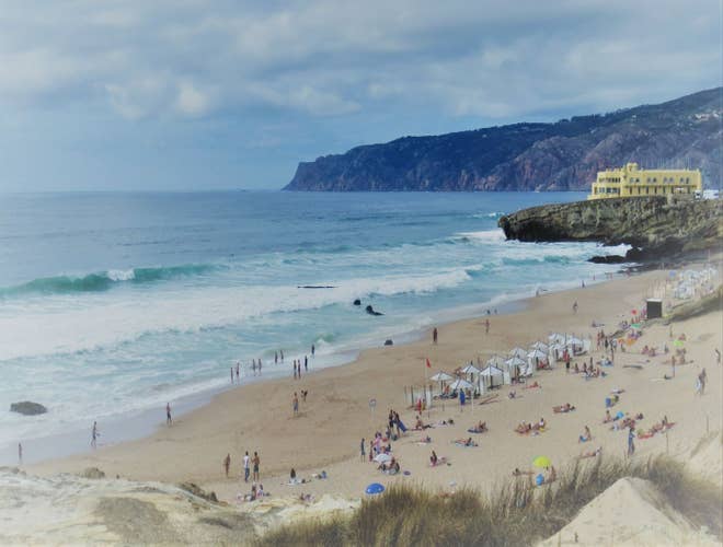 Crowds enjoying a summer day at Praia Grande in Sintra, a beautiful surf beach in Portugal in August..jpg
