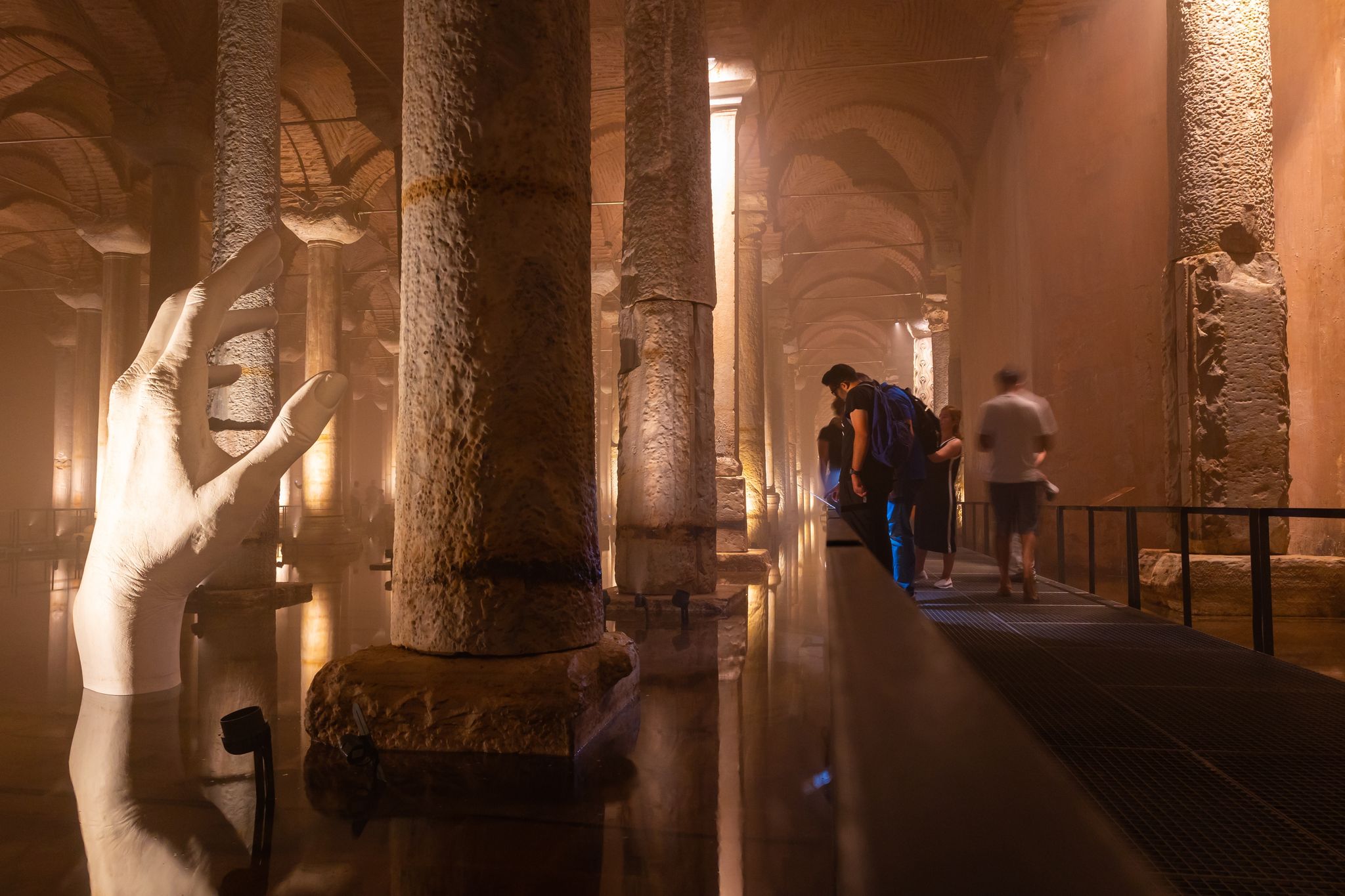 Tourists visiting the Basilica Cistern or Yerebatan Sarnici in Istanbul. Noise and grain included. Selective focus. Motion blur on people. Istanbul Turkey