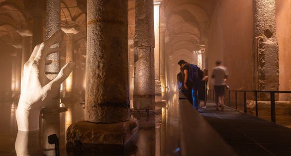 Tourists visiting the Basilica Cistern or Yerebatan Sarnici in Istanbul. Noise and grain included. Selective focus. Motion blur on people. Istanbul Turkey