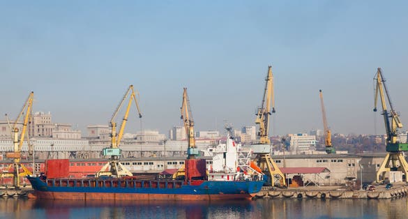 Seaport with cranes and moored dry cargo ship in Constanta Romania.