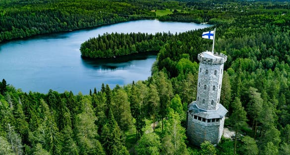 Photo of aerial view of Aulanko Observation Tower among blue lakes and green forests, Hameenlinna, Finland.