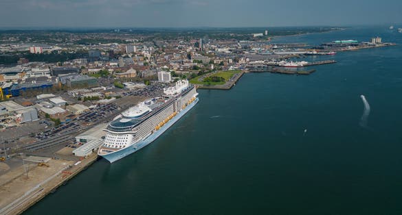 photo of view of  Large cruise ship moored at Southampton UK. Panoramic view of the Southampton city and the docks towards an open sea waters. High altitude aerial on a sunny day.