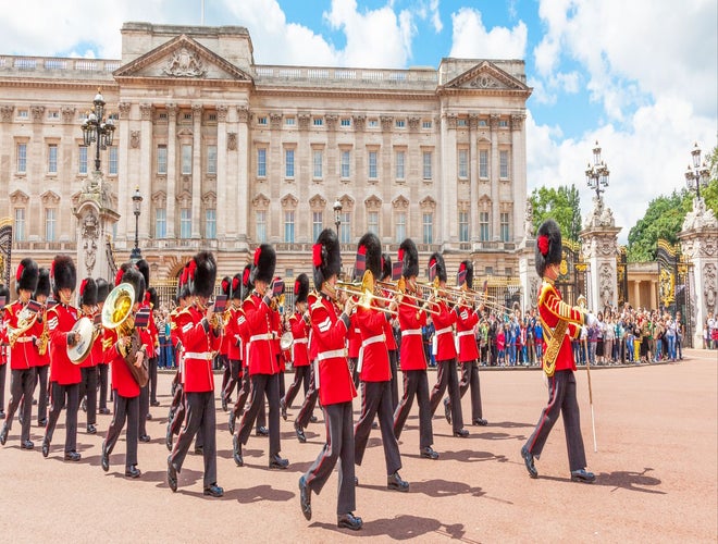 Changing of the Guard ceremony at Buckingham Palace with guards in red uniforms and bearskin hats..jpg