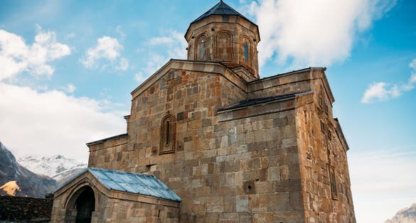 Photo of Famous Landmark Gergeti Trinity Tsminda Sameba Church In Early Winter. Gergeti Trinity Tsminda Is National Heritage Of Georgia.