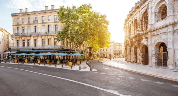 Photo of morning street view with roman amphitheater building in Nimes city on Southern France.
