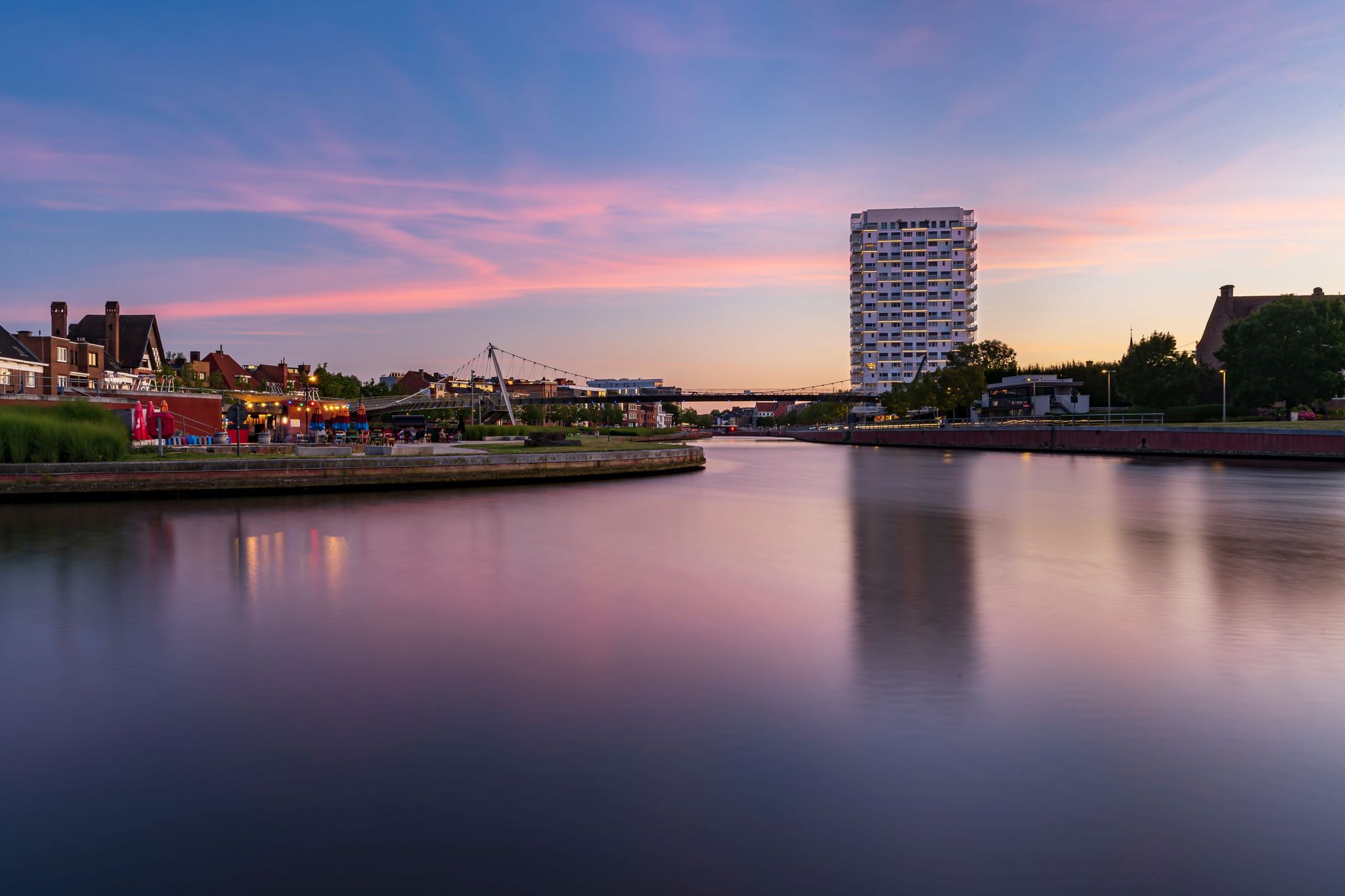 photo of view of A low-angle view of modern buildings near the lake at sunset in Kortrijk, Belgium