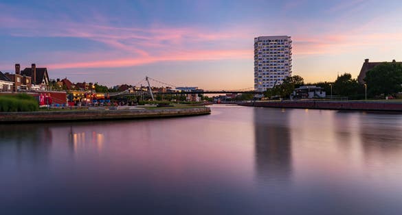 photo of view of A low-angle view of modern buildings near the lake at sunset in Kortrijk, Belgium