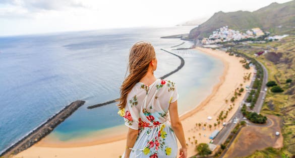 photo of beautiful girl enjoying the beach Playa de Las Teresitas (Santa Cruz de Tenerife) in Tenerife, Spain.