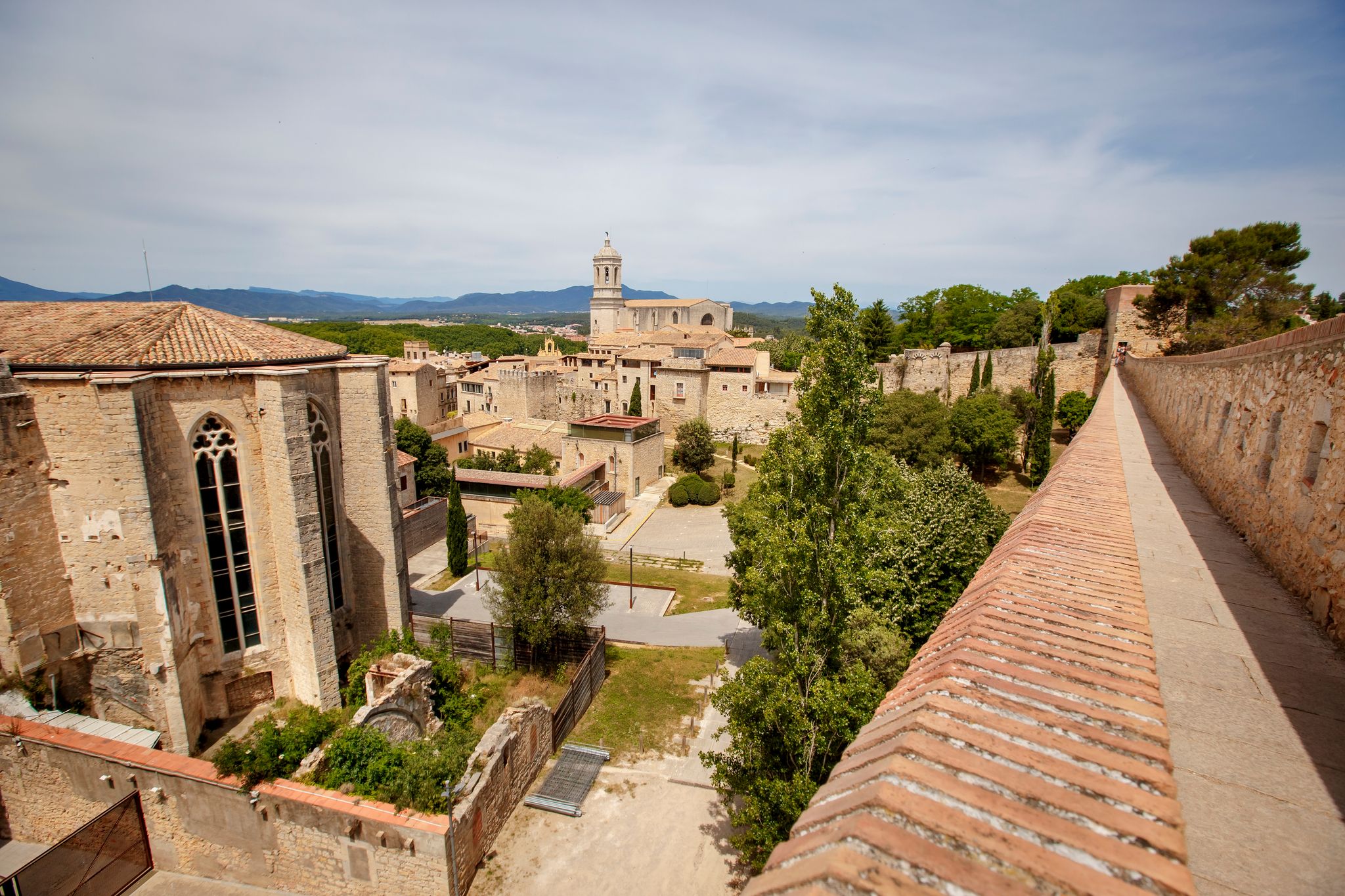 Photo of Girona old city wall fortification, venerable 9th-century city walls with walkways, towers and scenic vantage points of the area, city views of Girona, Catalonia, Spain.