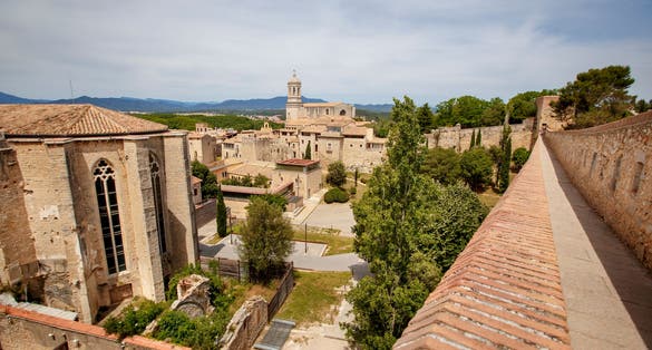 Photo of Girona old city wall fortification, venerable 9th-century city walls with walkways, towers and scenic vantage points of the area, city views of Girona, Catalonia, Spain.