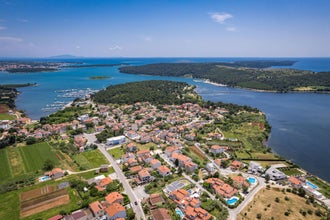 Photo of aerial view of the stunning Croatian coastal town of Pomer, with its picturesque oceanfront buildings and harbor.