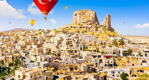 Hot air balloons flying over Uchisar Castle. Cappadocia. Nevsehir Province. Turkey.