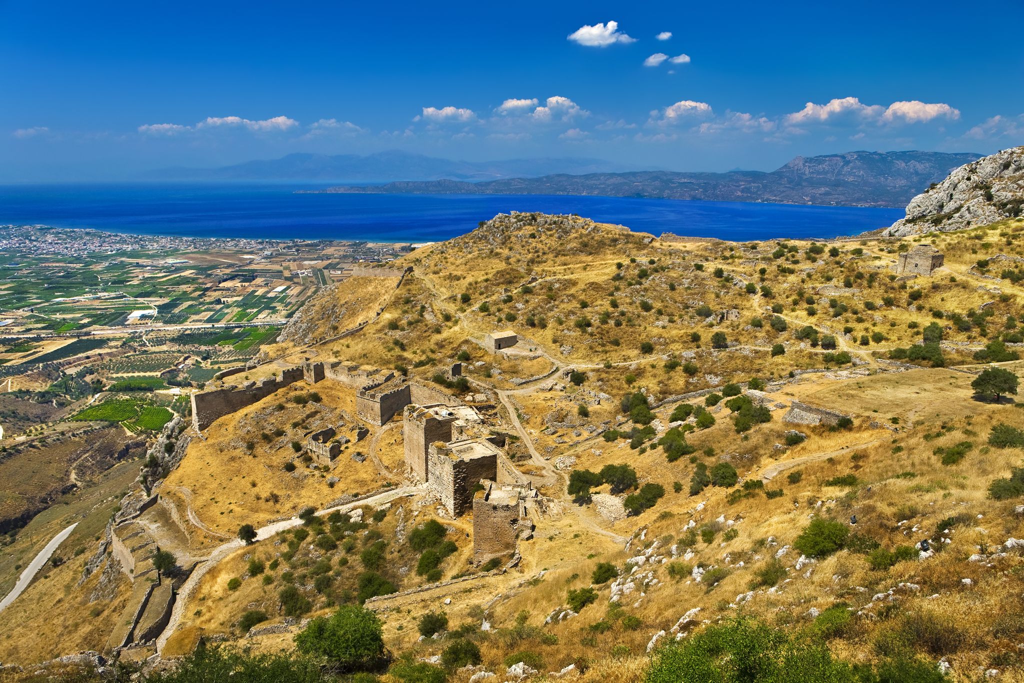 photo of Aerial view of Acrocorinth (the acropolis of ancient Corinth). There is the Corinthian Gulf in the background. Corinth, Greece.