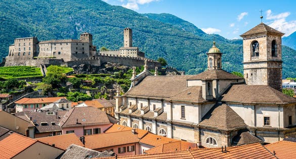 Photo of scenic cityscape of Bellinzona with Castelgrande castle and Chiesa Collegiata dei Santi Pietro e Stefano church in Ticino, Switzerland.