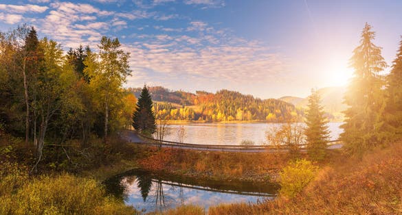 Picturesque autumn landscape with yellow trees, blue cloudy sky and reflection in the water, National park Slovak paradise, Slovakia