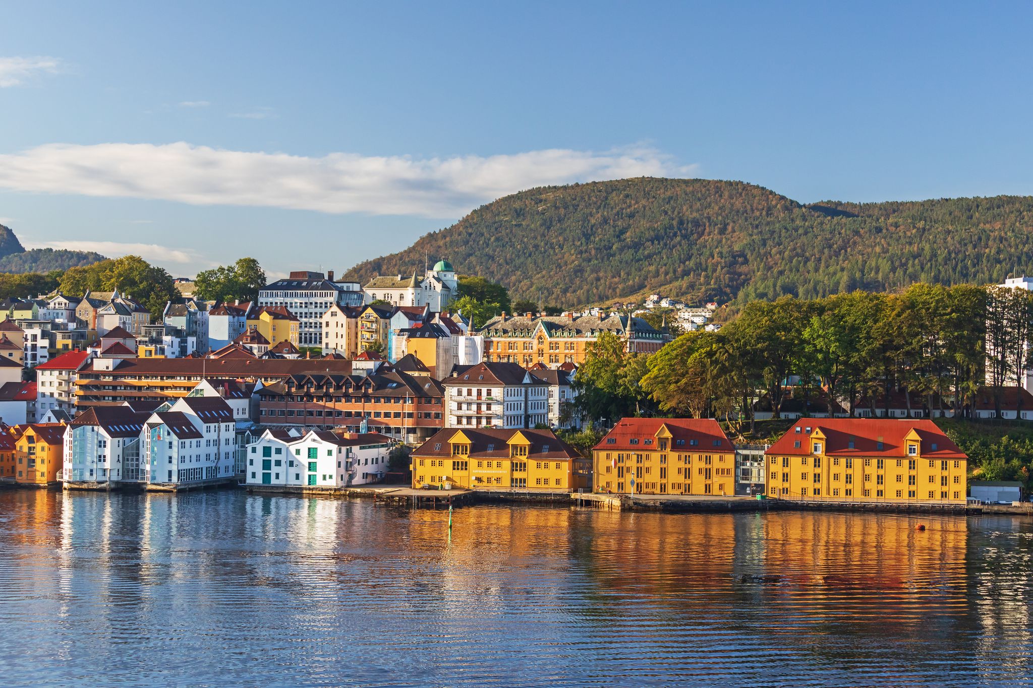 Colorful houses at the waterfront in Bergen, Norway, with reflection in the water, peninsula Nordnes in morning light