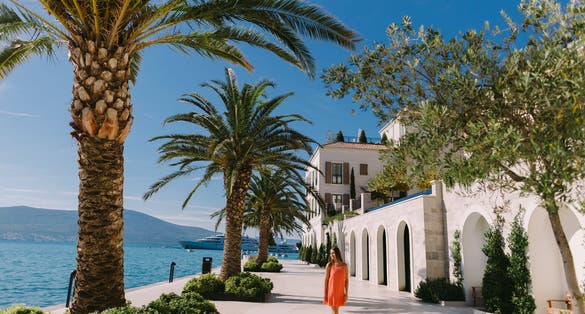 Photo of woman, palm trees and yachts background, Tivat, Montenegro.