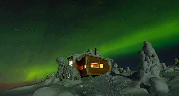 Photo of Chalet in top of Luosto with northern lights, Finland.