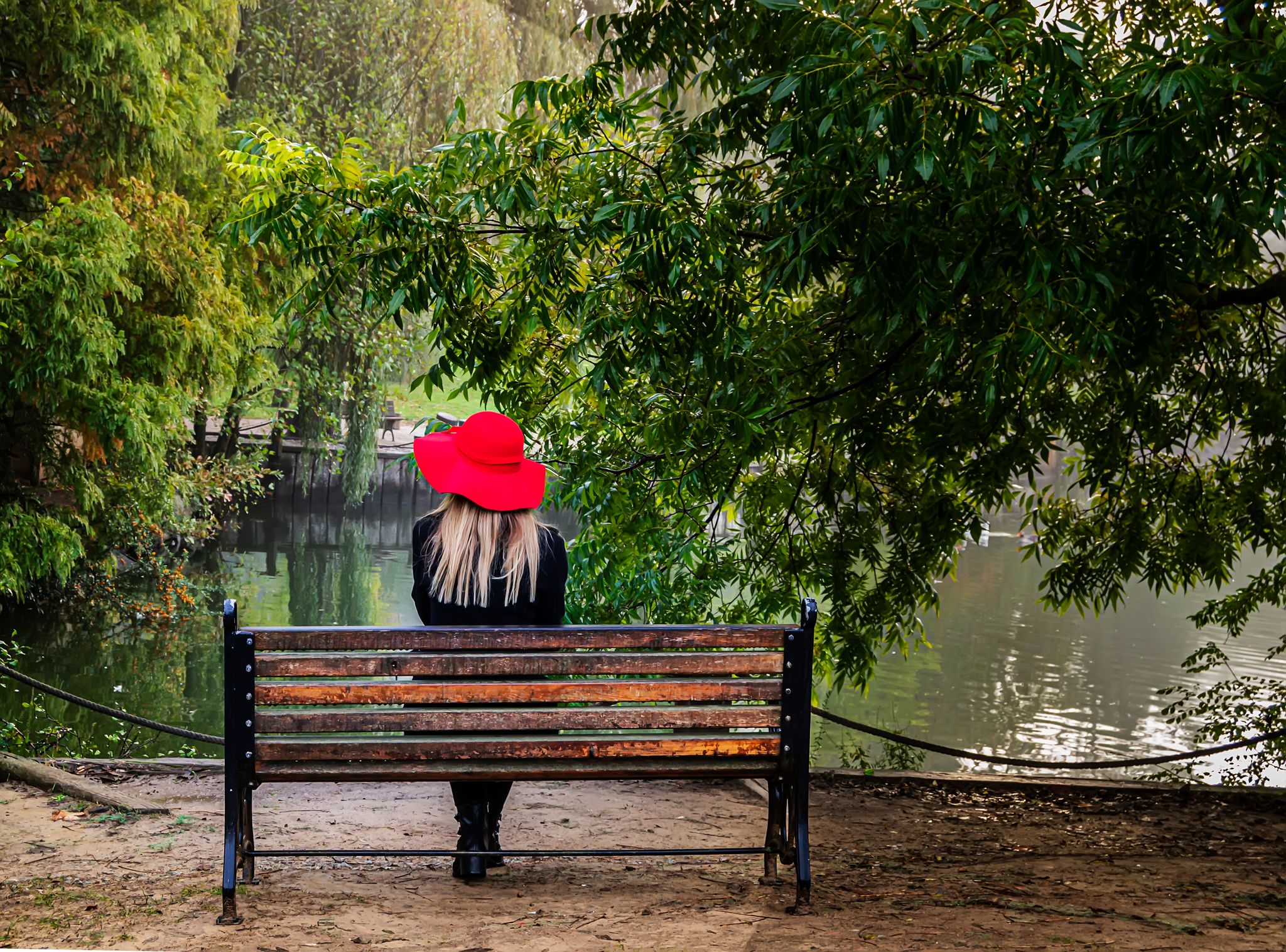 photo of portrait of a pretty young girl outside on a sunny day and sitting on the bench. Atatürk Arboretum, Istanbul, Turkey, November 4, 2017.