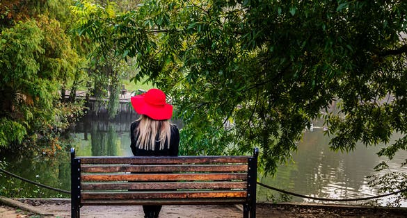 photo of portrait of a pretty young girl outside on a sunny day and sitting on the bench. Atatürk Arboretum, Istanbul, Turkey, November 4, 2017.
