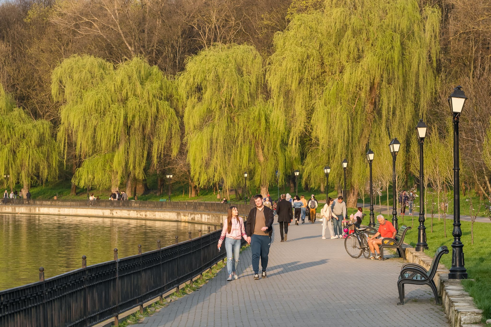 photo of Chisinau, Moldova - April 21, 2021: Street scene from Chisinau, Moldova. Unidentified people walk on waterfront of valea morilor lake in city park at early spring in Chisinau.