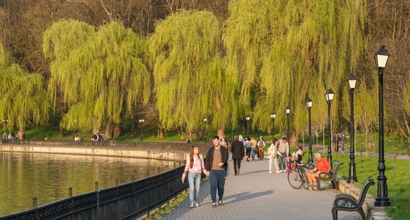 photo of Chisinau, Moldova - April 21, 2021: Street scene from Chisinau, Moldova. Unidentified people walk on waterfront of valea morilor lake in city park at early spring in Chisinau.