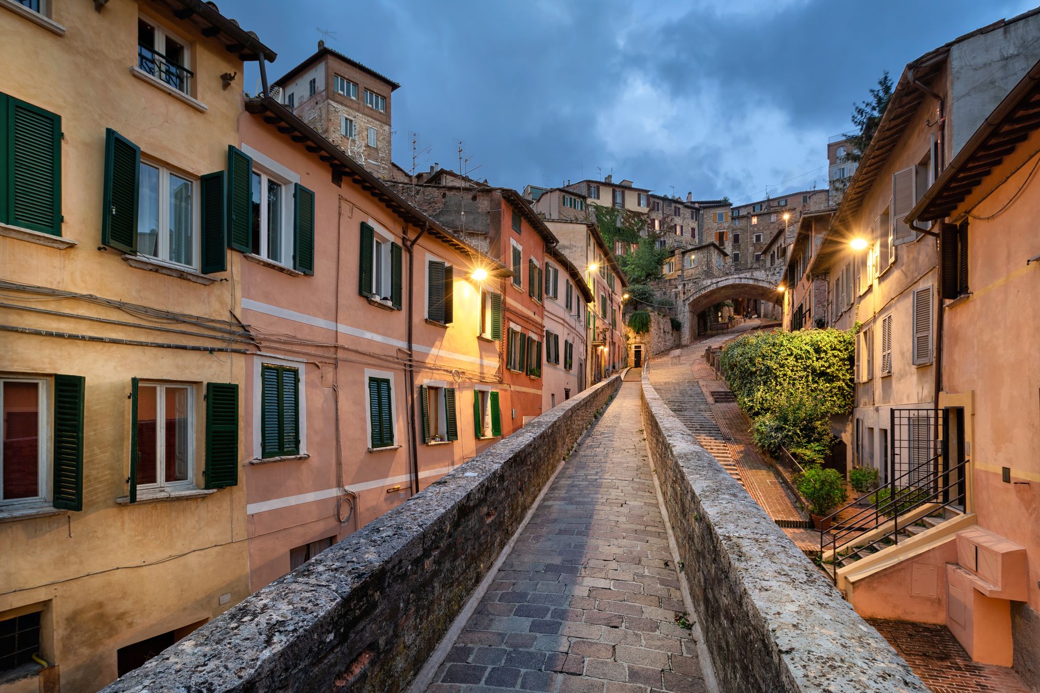 PHOTO OF Perugia, Italy. Medieval aqueduct and colorful buildings at dusk .
