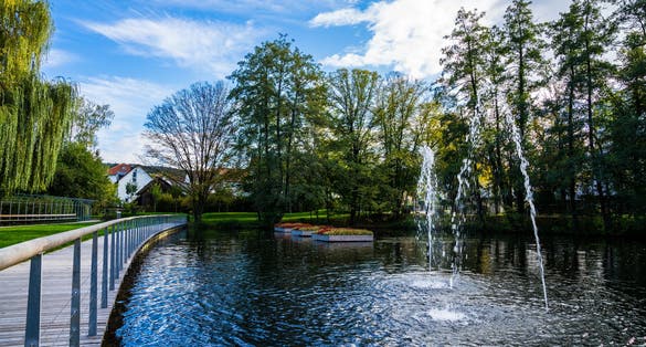Germany, Beautiful public park feuersee in schorndorf city with a small lake and fountains surrounded by trees