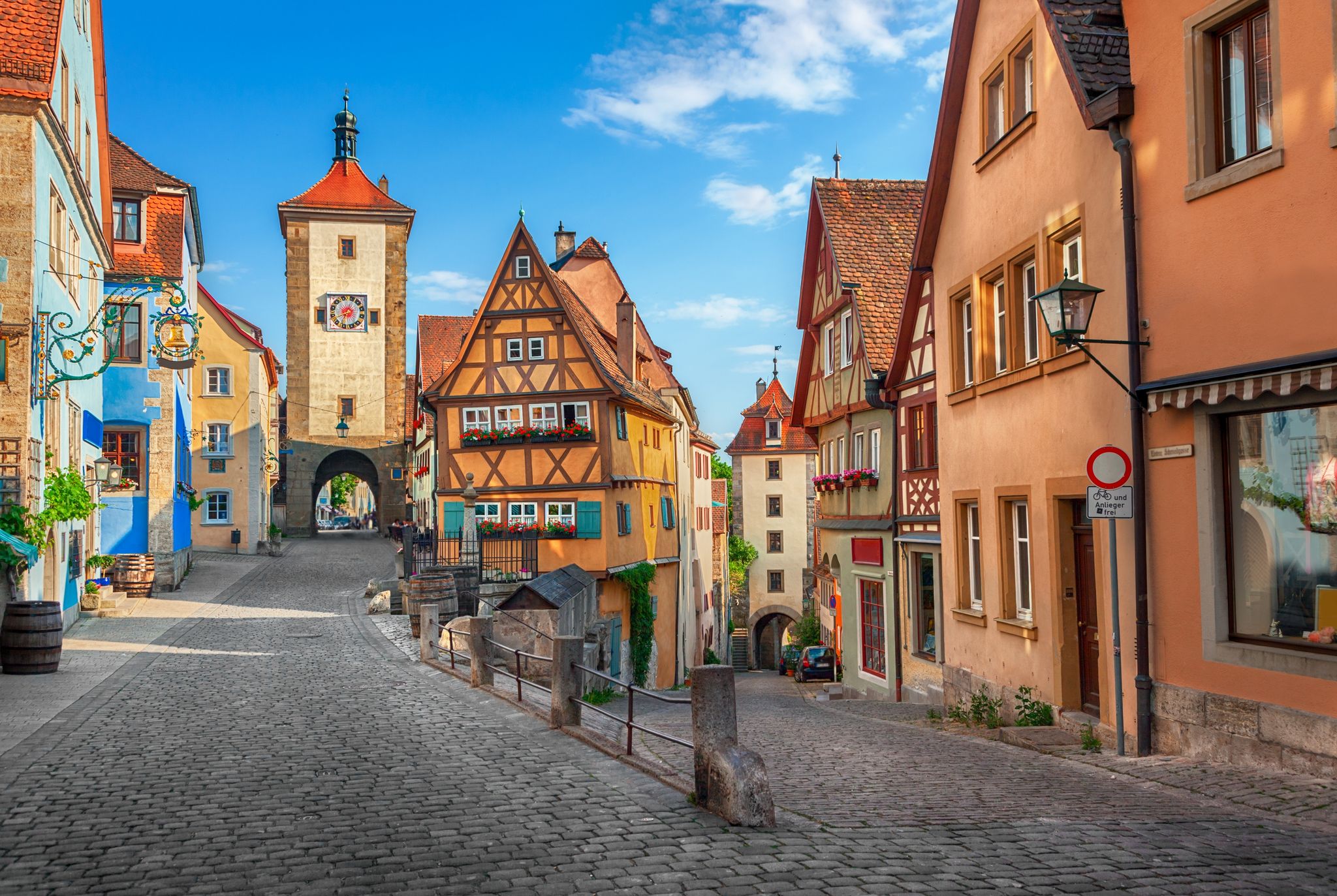 Beautiful postcard view of the famous historic town of Rothenburg ob der Tauber on a sunny day with blue sky and clouds in summer, Franconia, Bavaria, Germany