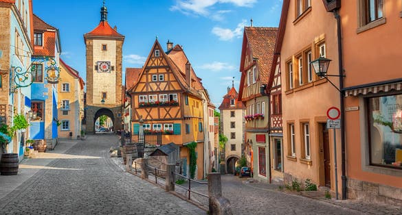 Beautiful postcard view of the famous historic town of Rothenburg ob der Tauber on a sunny day with blue sky and clouds in summer, Franconia, Bavaria, Germany