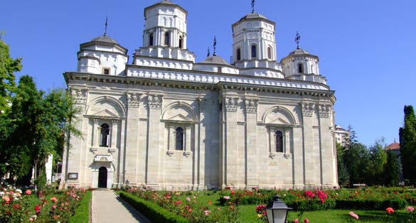 photo of Golia Monastery Iasi with blue sky behind in the summer .