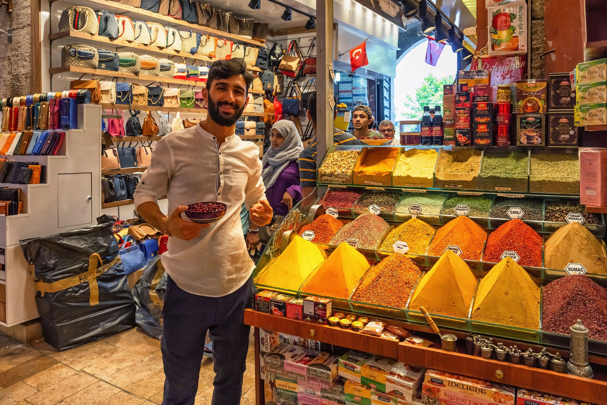  Unknown young seller man stand near with the spices on the shelves in Spice Bazaar (Egyptian Bazaar) in Istanbul. Is one of the largest bazaars in the city.