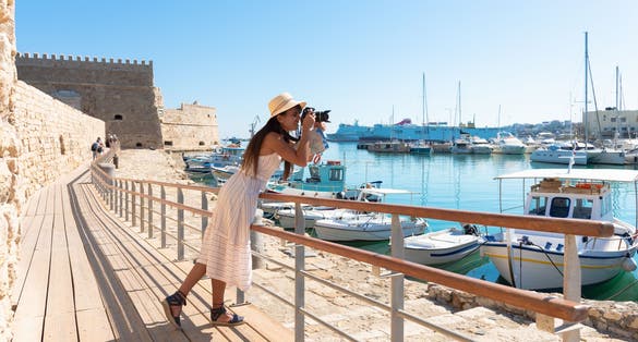 Photo of tourist woman on vacation in Heraklion Crete walking at the port.